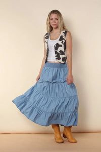 A flowing light blue elastic tiered midi denim skirt with a gathered waistband and ruffled layers