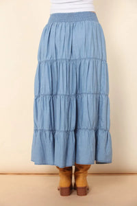 A light blue elastic tiered midi denim skirt with a smocked waistband in a tiered midi denim style