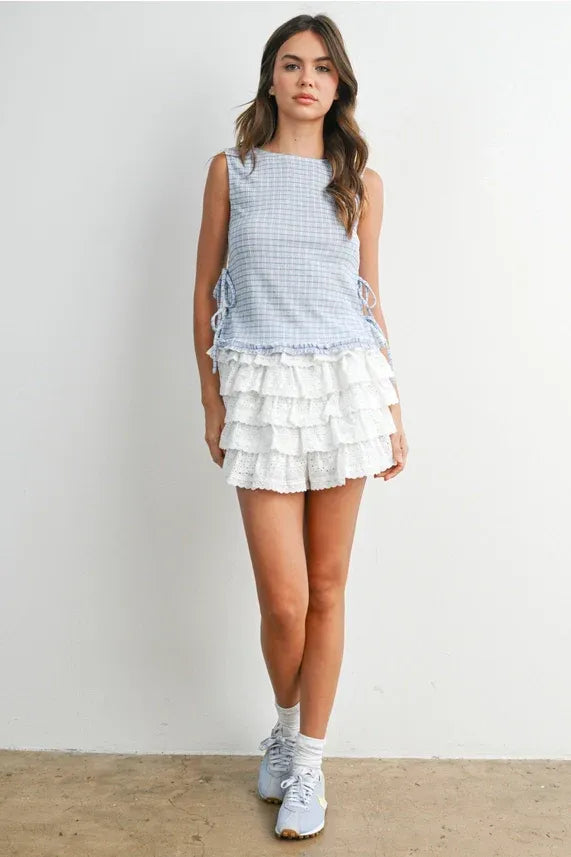 A light blue and white checkered ladder lace sleeveless top with ruffled side ties for a stylish look
