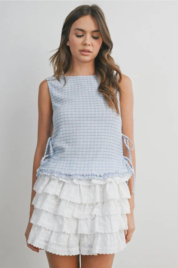 A light blue and white checkered ladder lace sleeveless blouse with ruffled tiers at the hem