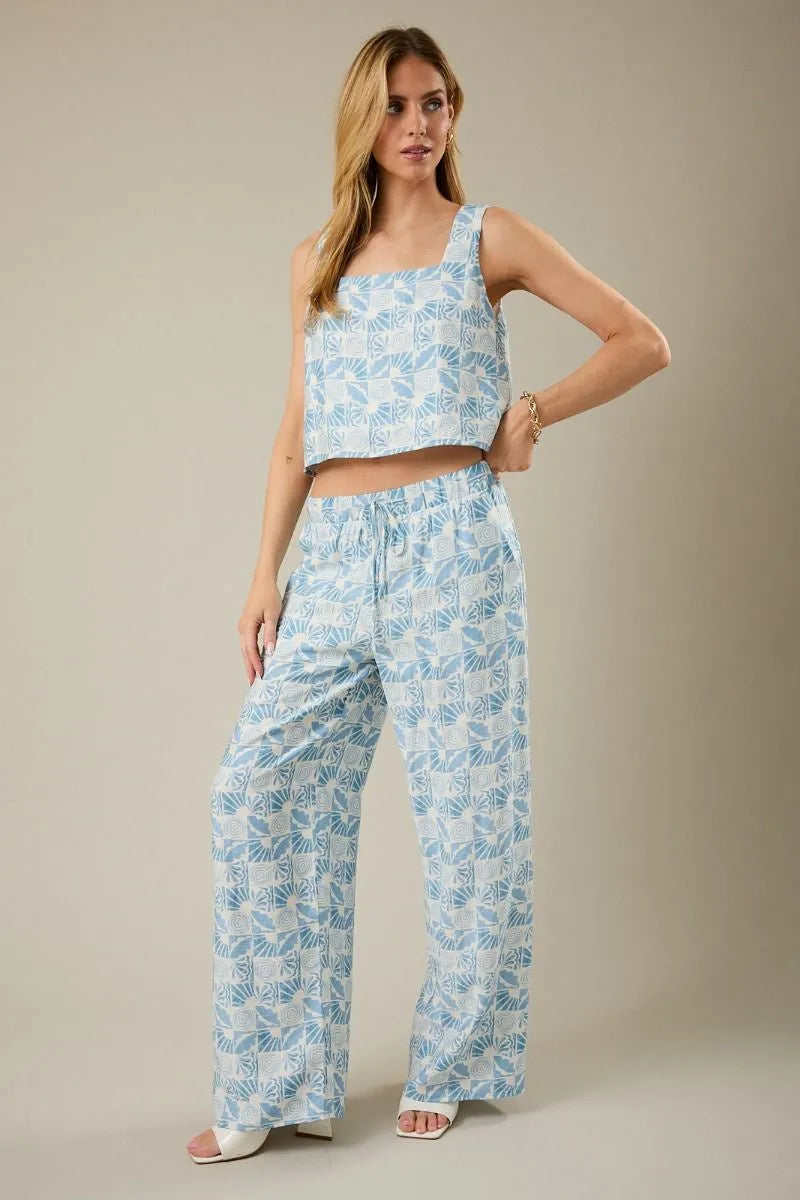 A light blue and white abstract print two-piece outfit with elastic waist tie pants and a square-neck crop top