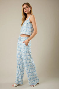 Light blue and white wide-leg abstract print pants with elastic waist tie featuring geometric leaf pattern