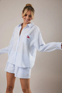 Light blue and white vertically striped oversized button-down stripe shirt with red lobster embroidery on chest pocket for women’s boho chic clothing