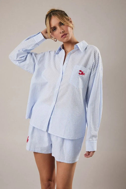 Light blue and white striped oversized button-up shirt with red lobster embroidery on left chest pocket for women’s boho chic clothing