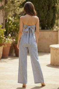 Light blue and white vertically striped strap tube jumpsuit with tie strap back detail in a strapless design