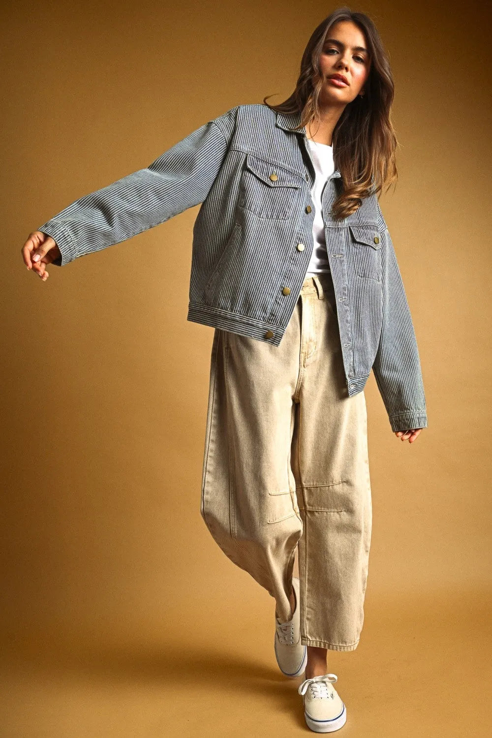 A light blue and white striped pattern denim jacket with classic button closures in a striped pattern denim design
