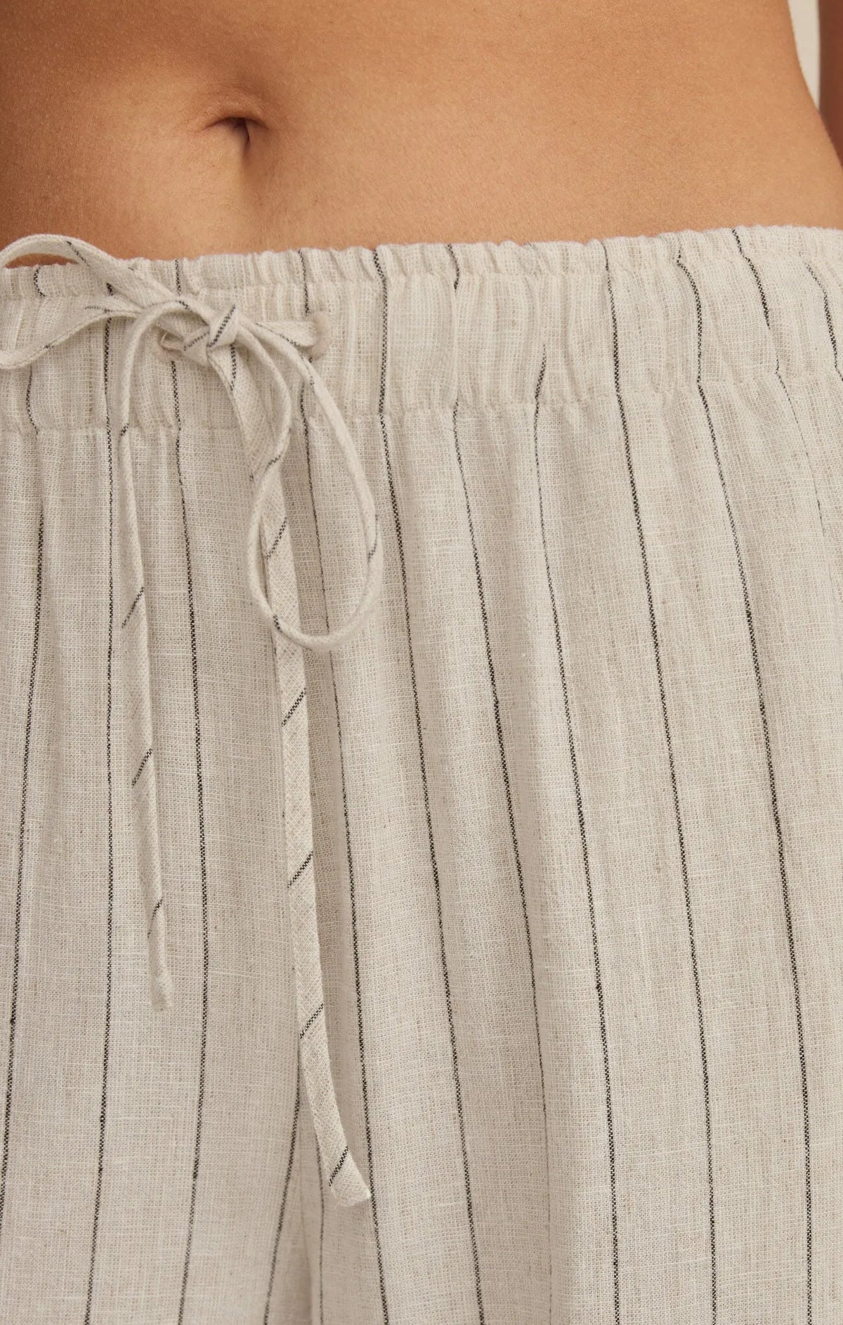 Light gray linen henri striped wide leg pants with thin black vertical stripes and matching drawstring waistband