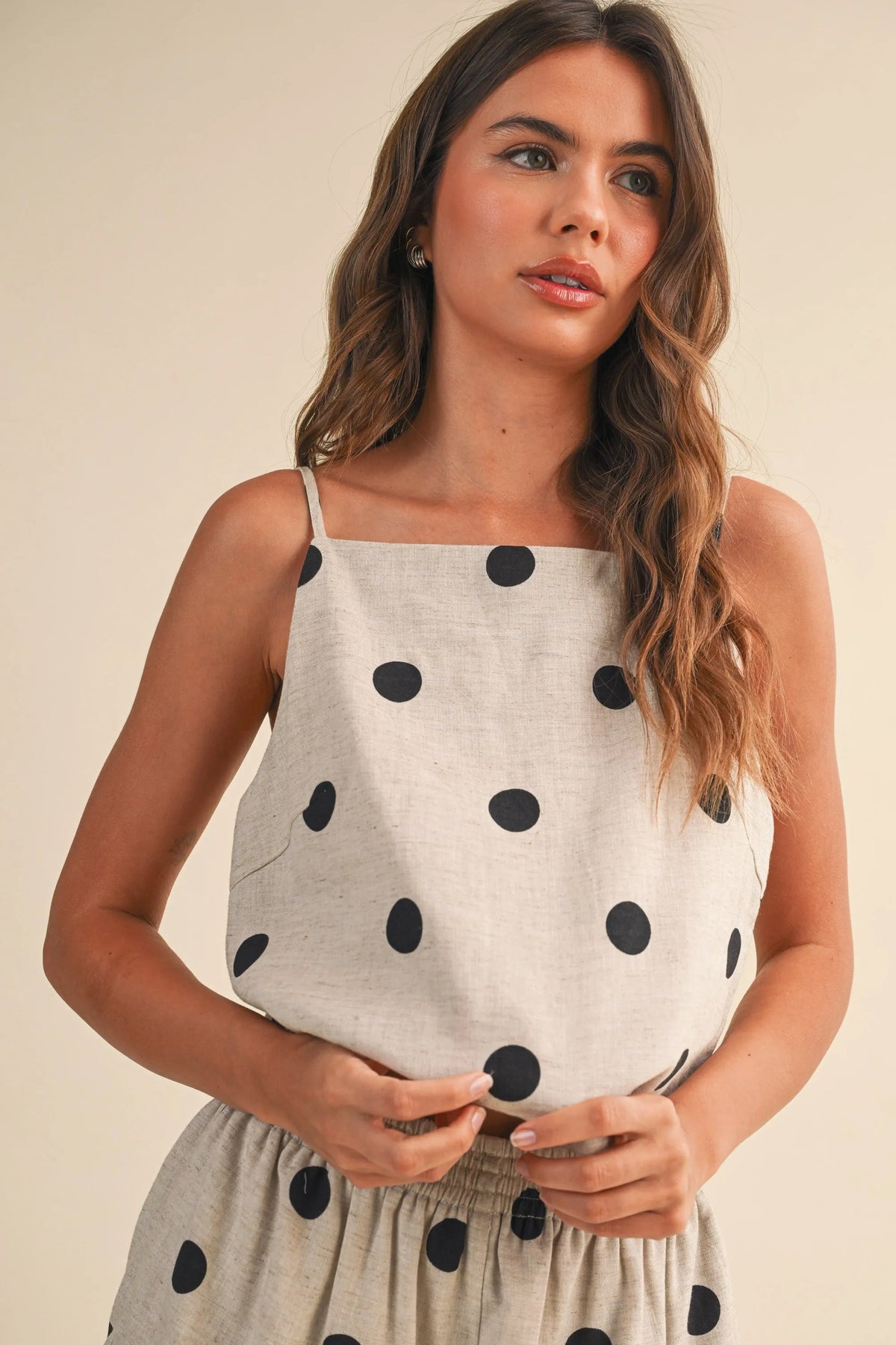 A light gray polka dot linen sleeveless top with thin straps perfect for casual summer wear