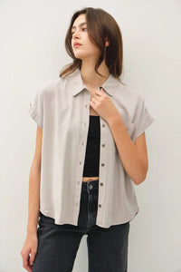 A light gray short dolman sleeve button shirt with relaxed fit and subtle collar pleats for casual wear