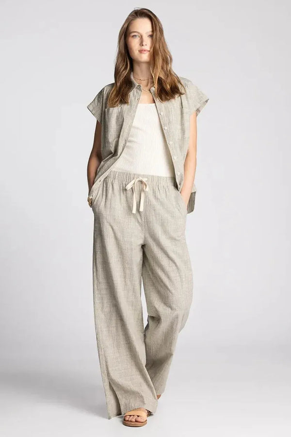 A light gray textured linen pantsuit with a relaxed fit and drawstring waist complementing supply sable short sleeve button shirt