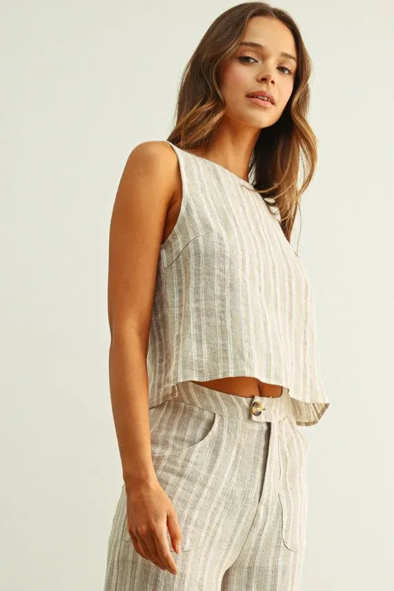 A light gray and white vertically striped sleeveless crop top made of jacquard linen with a linen twisted tie back detail
