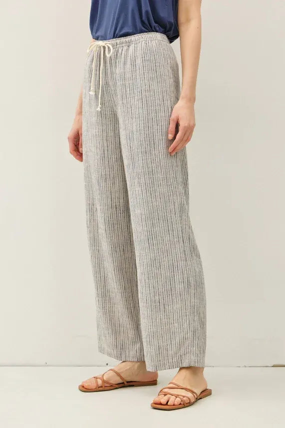 Light gray and white stripy linen wide leg pants with elastic waistband and matching drawstring pull on style