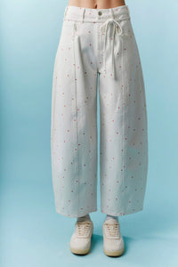Light gray wide-leg trousers with mini bow print drawstring waist and subtle red dot pattern in high waist design