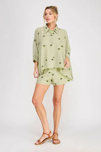 Light green palm tree crinkled woven blouse with a subtle palm tree print and button-up design