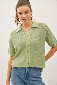 A light green boxy crochet collared short sleeve cardigan with buttons and collar made from knitted fabric