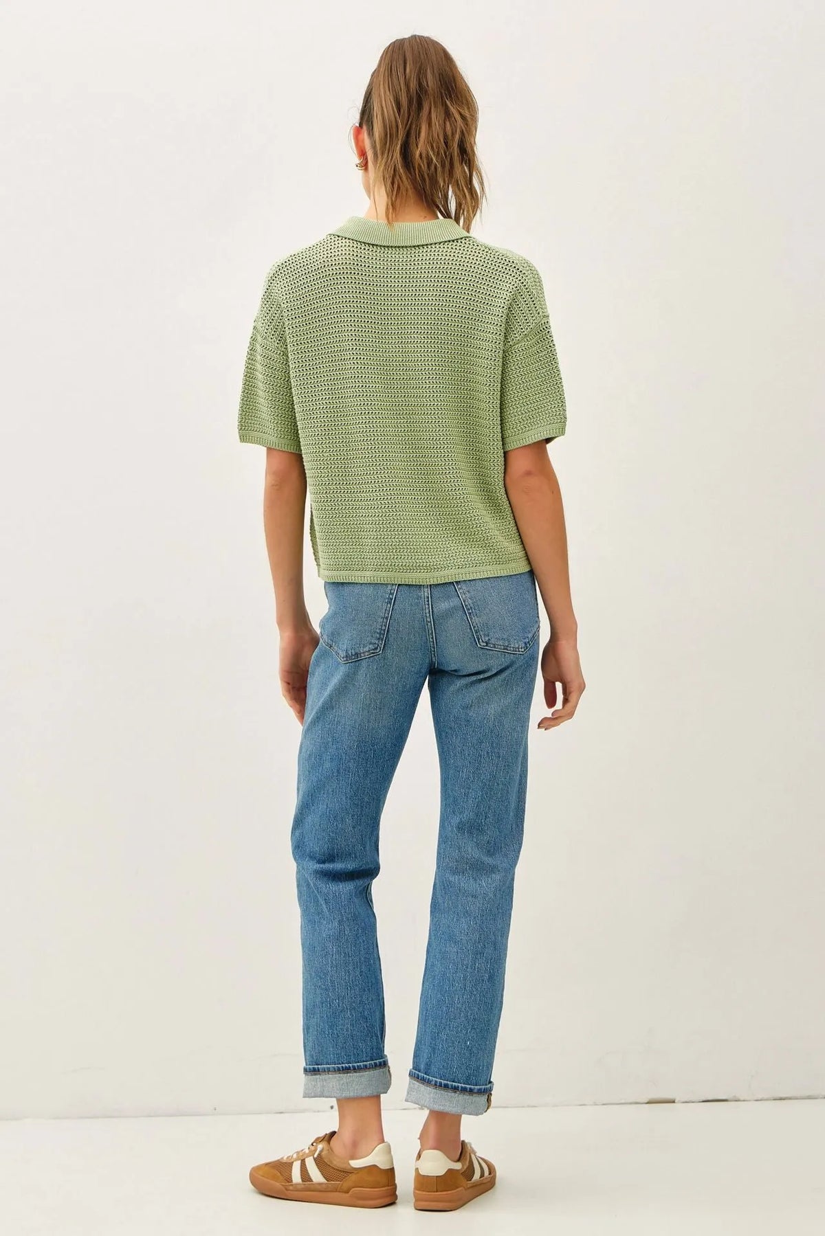 A light green boxy crochet collared short sleeve cardigan with textured knitted fabric and a polo shirt design
