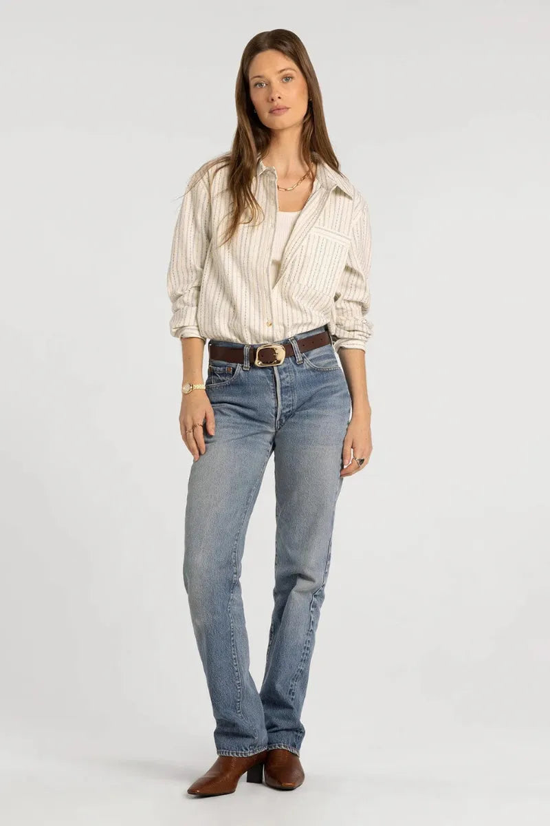 Light-wash blue denim jeans with classic straight-leg cut and brown leather belt buckle styled with thread & supply lexington shirt