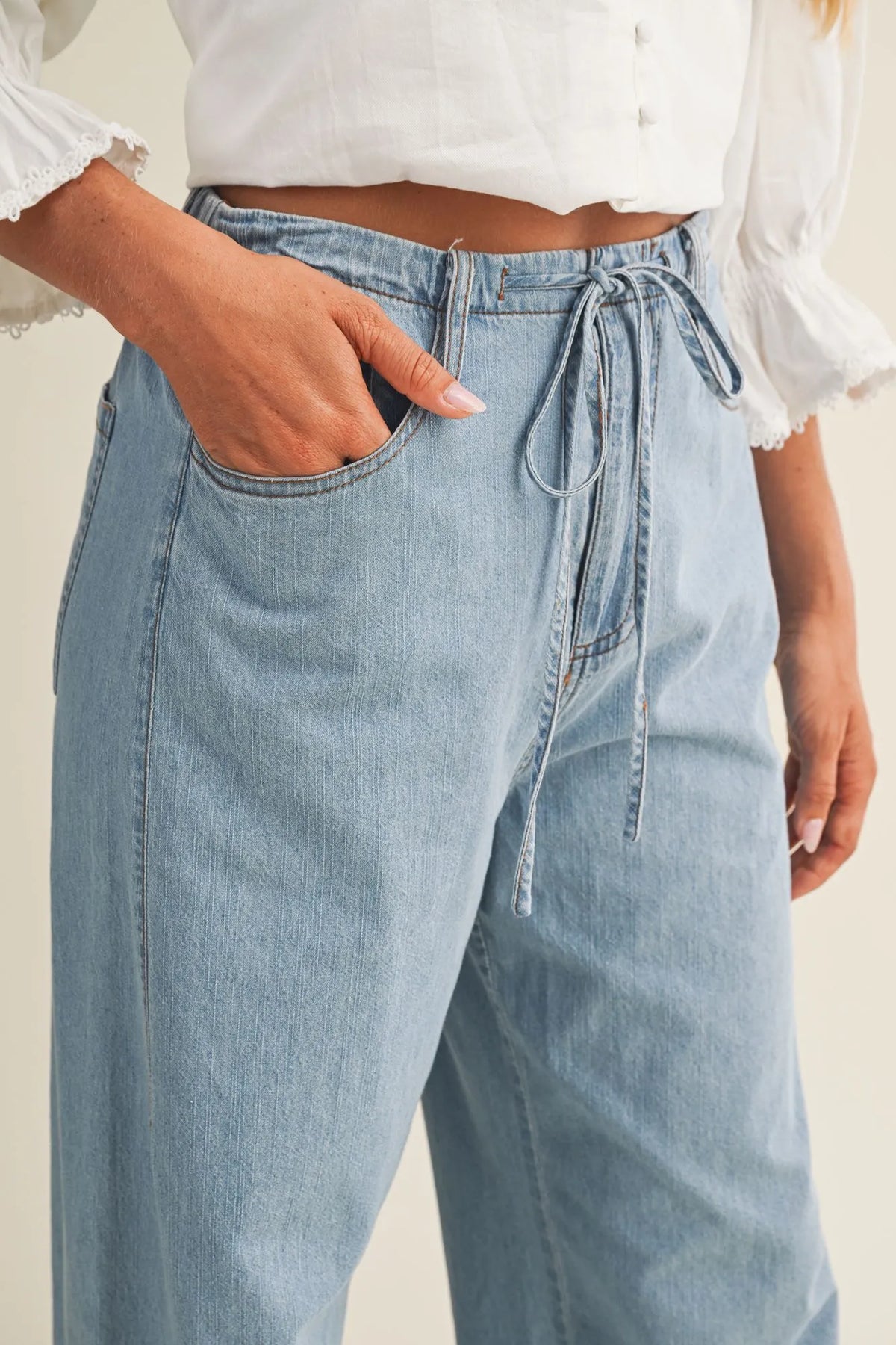Light-wash relaxed denim pants with a drawstring waist and wide legs for comfortable casual wear
