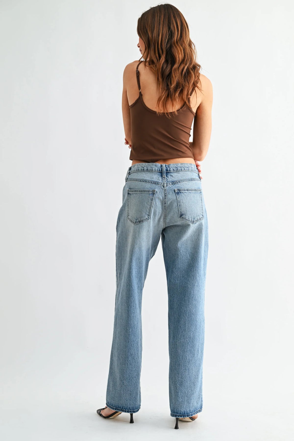 Back side of mid rise lightweight relaxed straight light-wash denim jeans with wide-leg cut and classic back pockets
