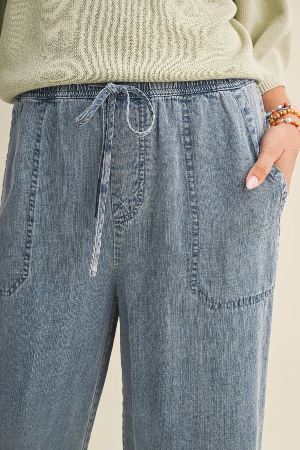 Light-wash denim drawstring waist patch wide leg pants with front waist patch pockets and a comfortable fit