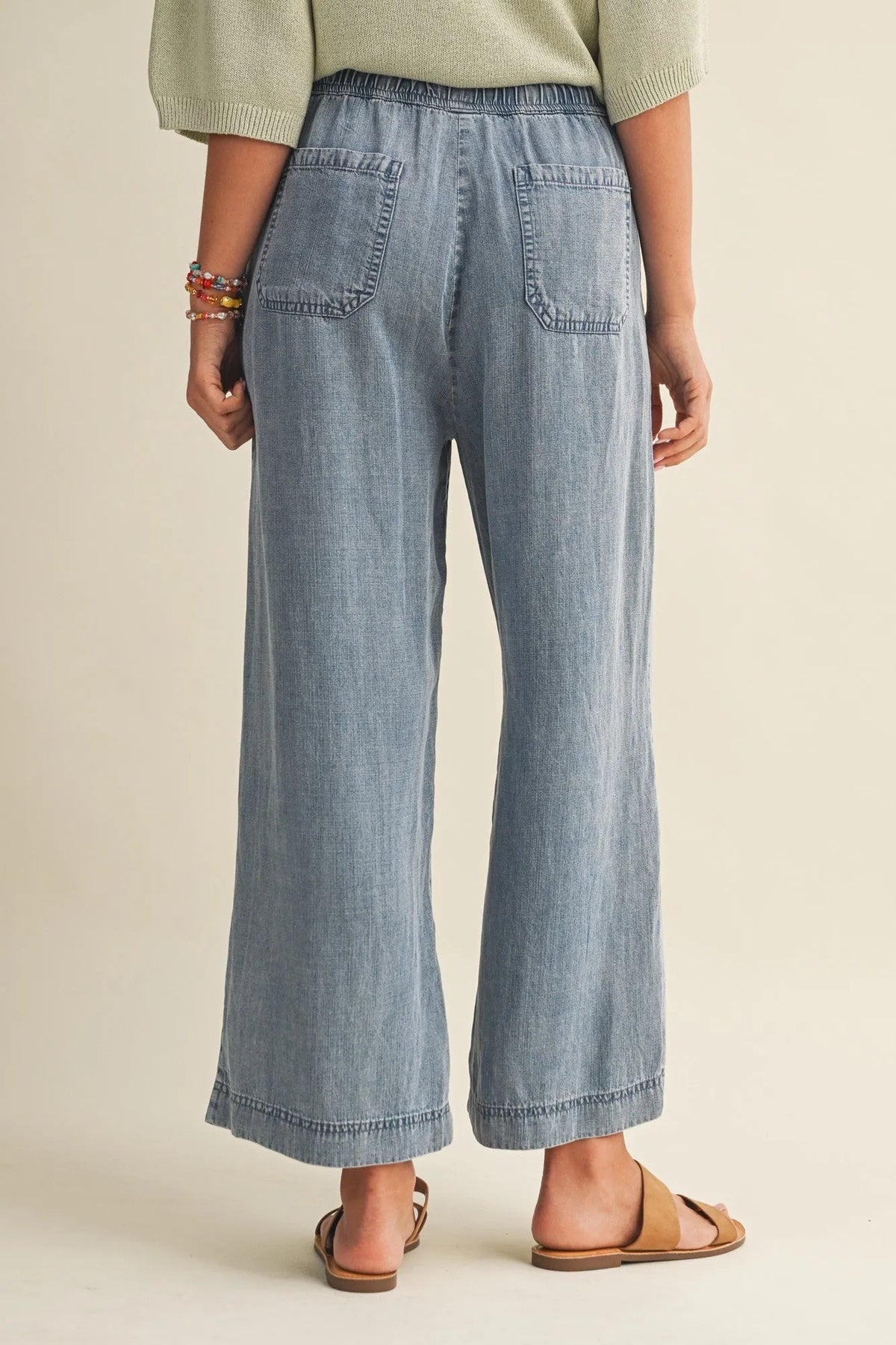 Light-wash denim drawstring waist patch wide-leg pants with relaxed fit and two back waist patch pockets from back view