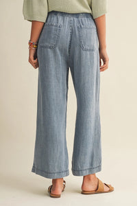 Light-wash denim drawstring waist patch wide-leg pants with relaxed fit and two back waist patch pockets from back view