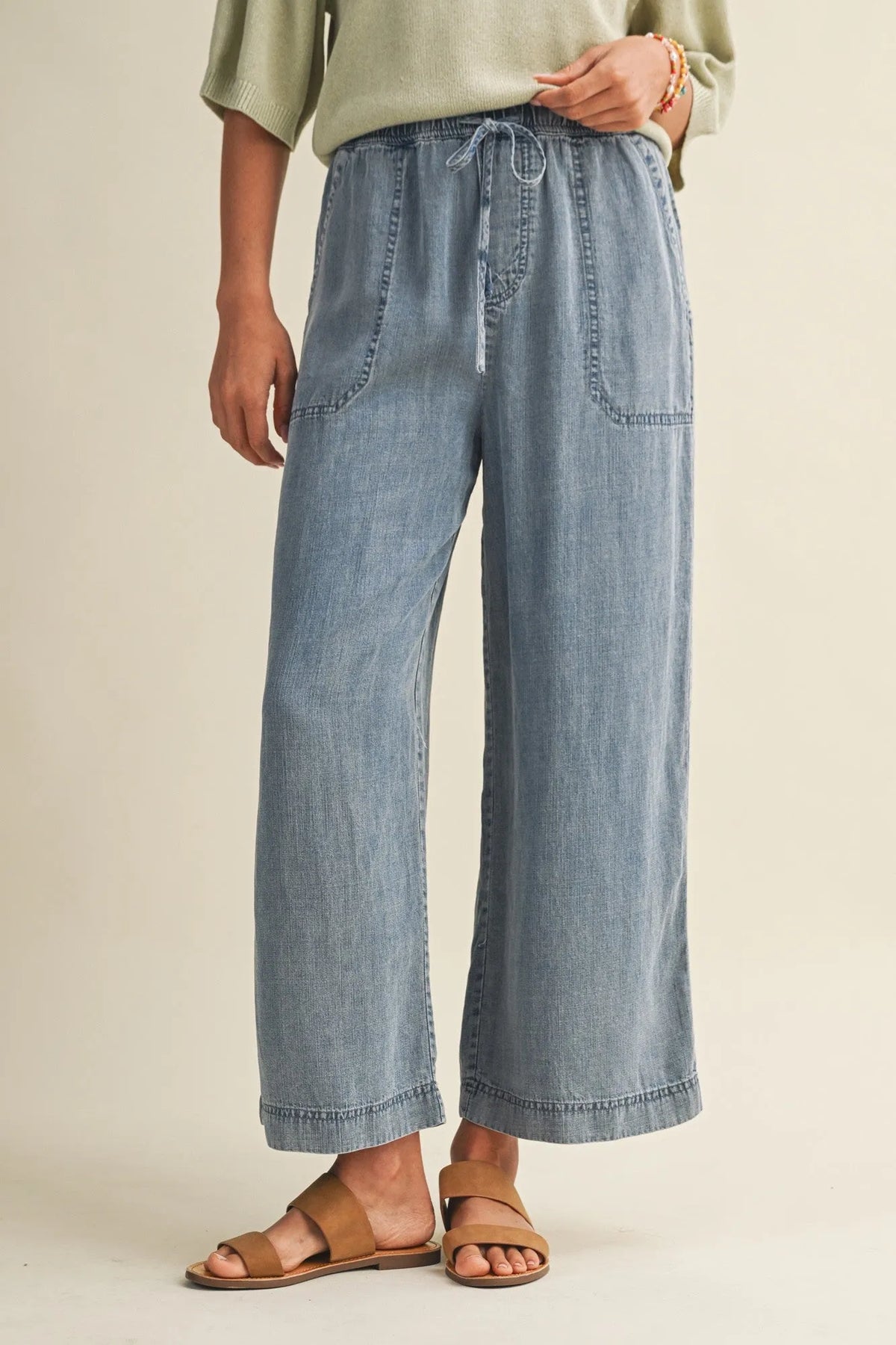 Light-wash denim wide-leg pants with a drawstring waist and waist patch pockets for casual wear