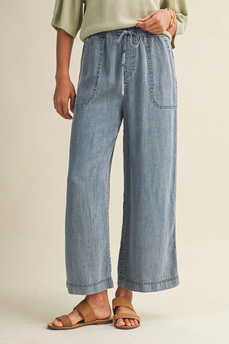 Light-wash denim wide-leg pants with a drawstring waist and waist patch pockets for casual wear