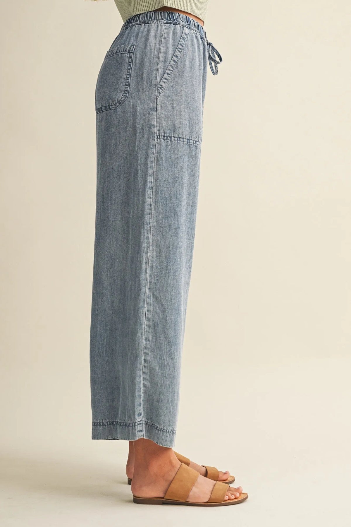 Light-wash denim wide-leg pants with a drawstring waist patch pocket and elastic waistband for relaxed fit