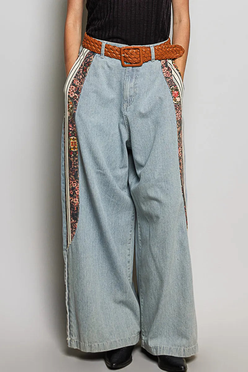 Light-wash relaxed fit pointed denim wide-leg pants with floral side panels and a brown woven belt for women’s boho chic clothing