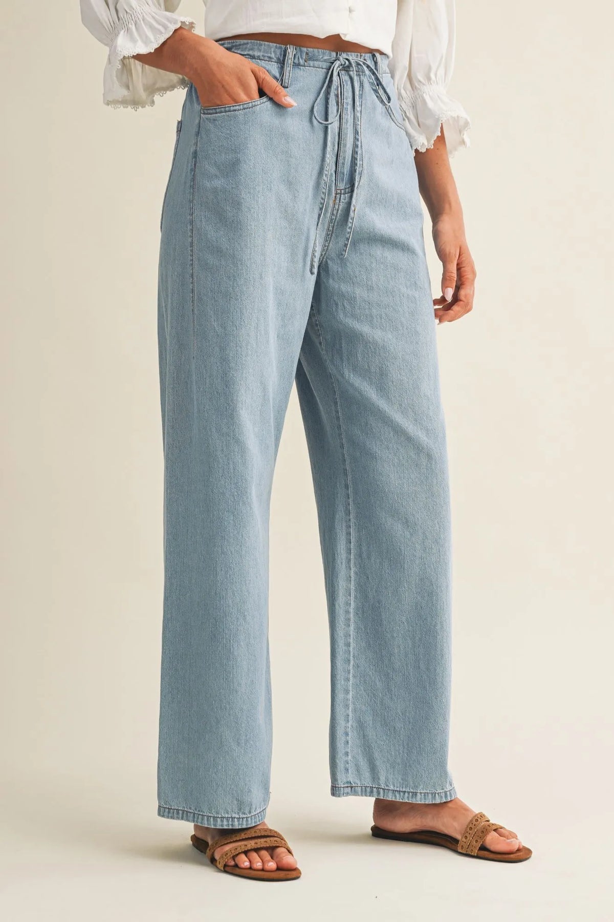 Light-wash relaxed denim pants with a drawstring waist featuring wide-leg design and comfortable fit