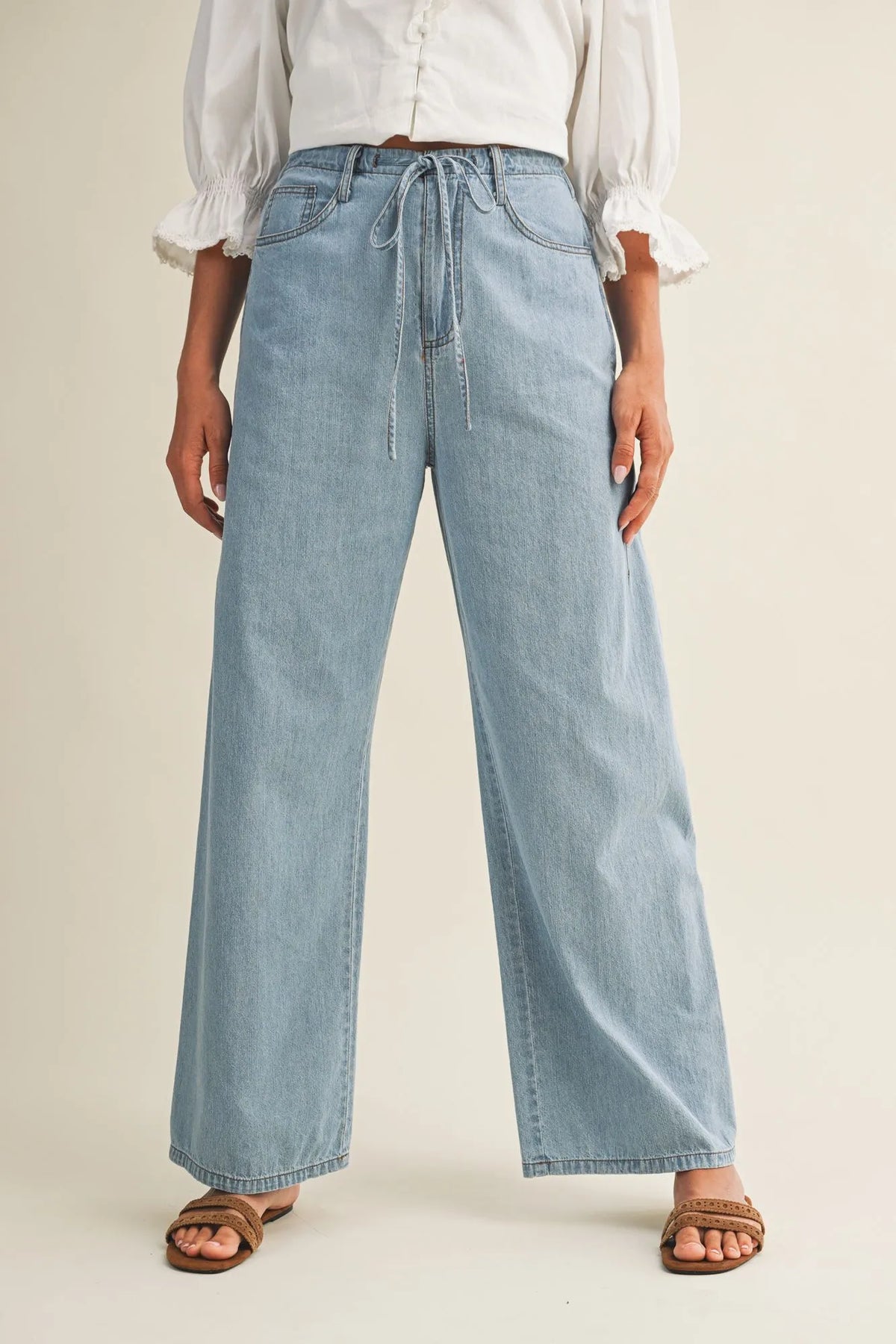 Light-wash relaxed denim pants with a drawstring waist in wide-leg style for casual comfort