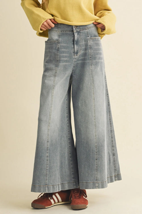 Light-wash vertical seam wide denim pants with high waist and visible stitching details in a wide leg design