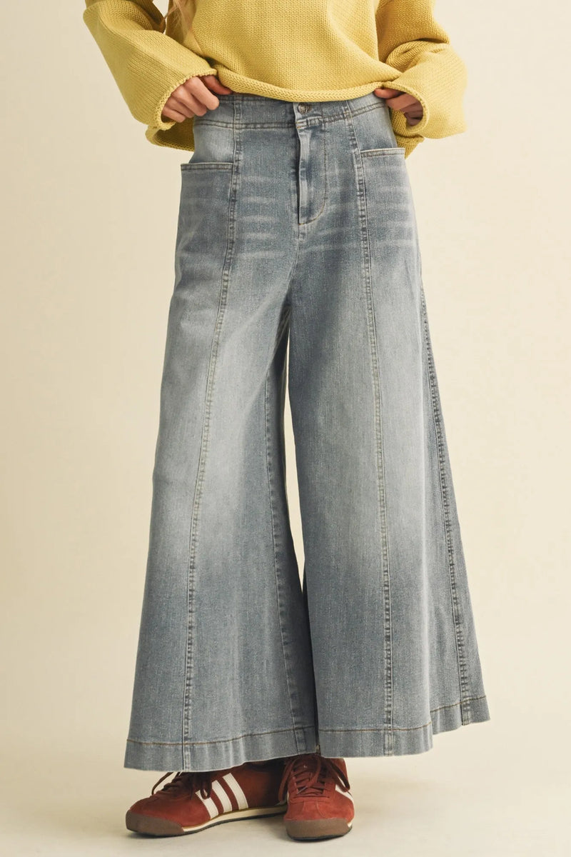 Light-wash vertical seam wide denim pants with high waist and visible stitching details in a wide leg design