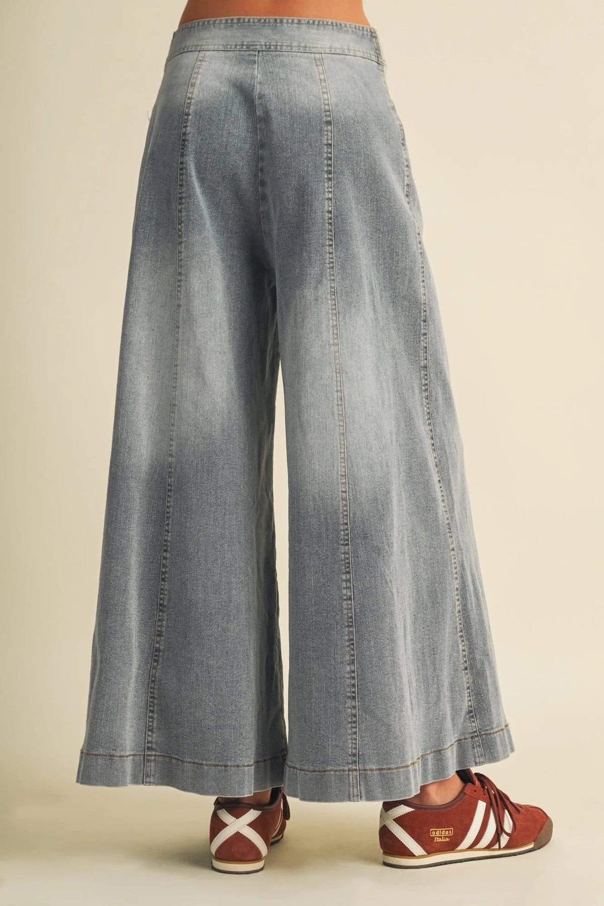 Light-wash denim vertical seam wide leg pants with a relaxed flowing silhouette and visible stitching details