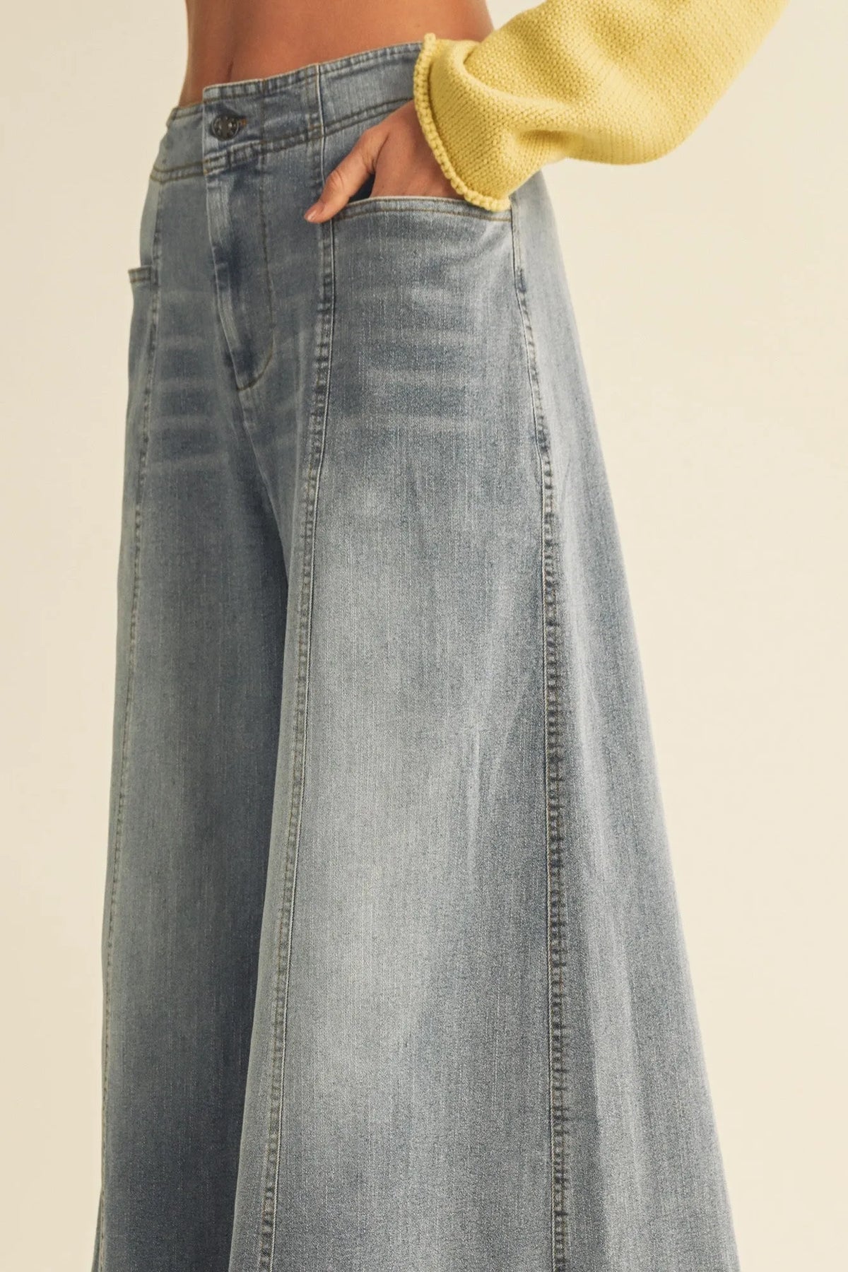 Light-wash vertical seam wide leg denim pants with relaxed flowing silhouette and visible side seam stitching