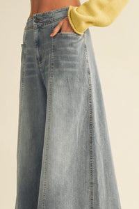 Light-wash vertical seam wide leg denim pants with relaxed flowing silhouette and visible side seam stitching
