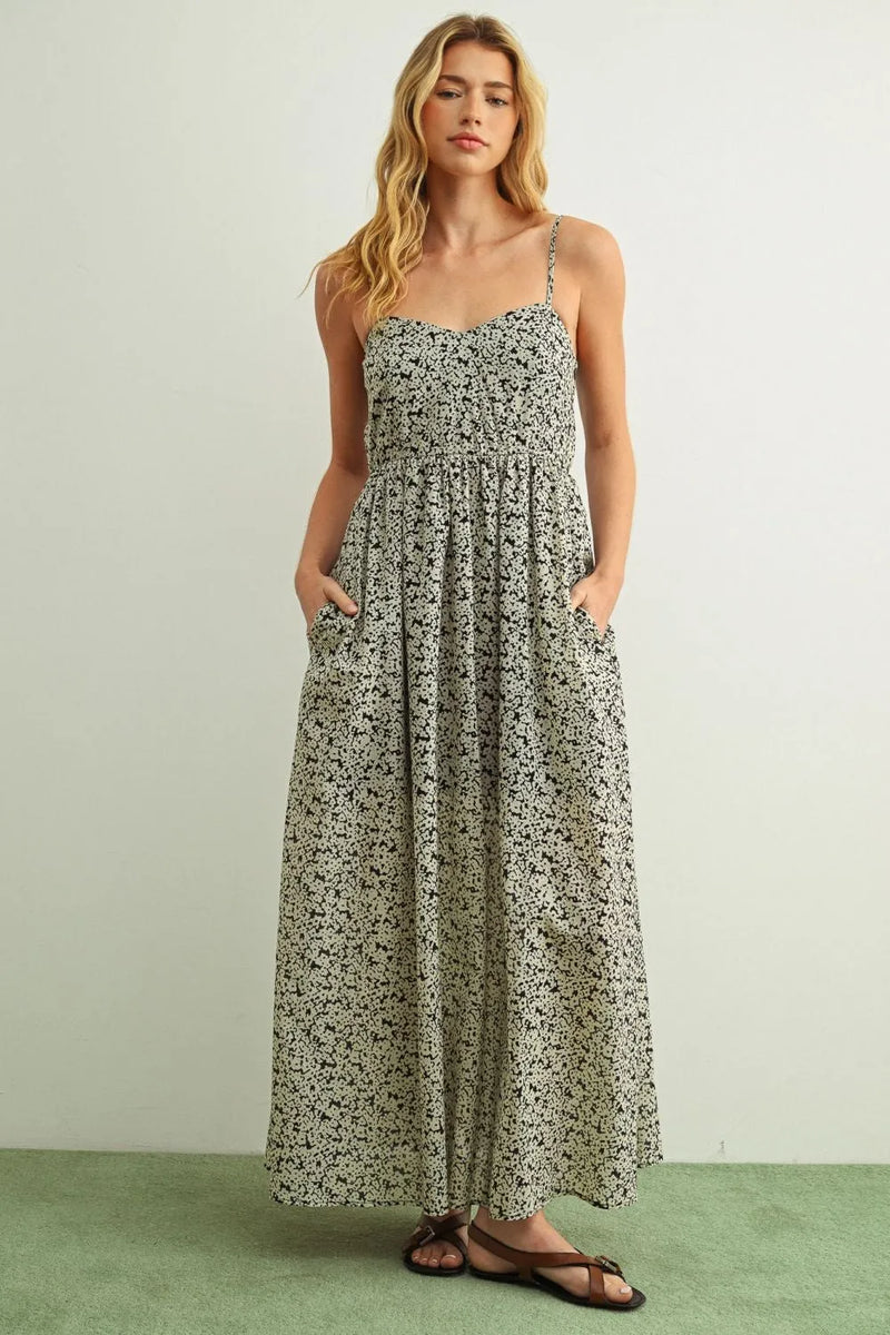 A soft sage green floral print maxi summer dress with long sleeves and delicate black floral patterns