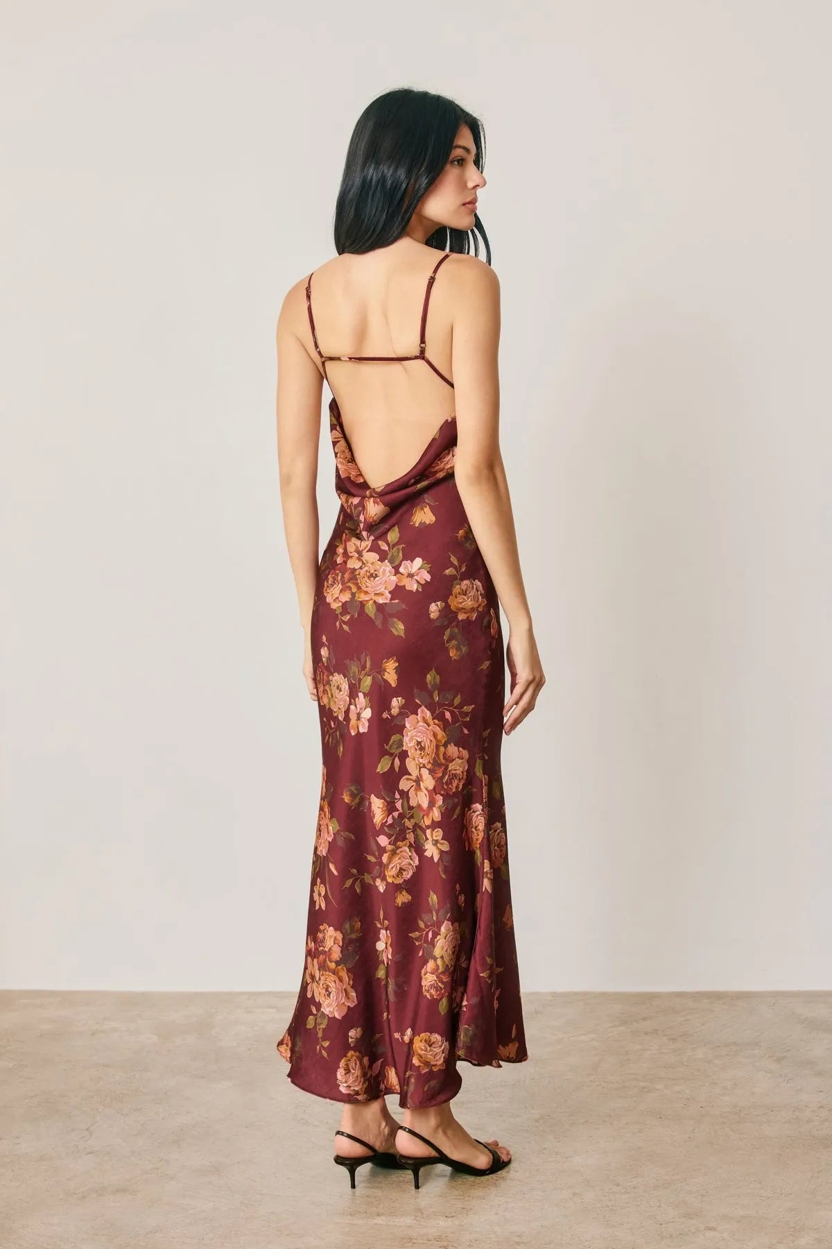 A flowing maroon satin floral chevron seam maxi dress with thin straps and chevron seam open back design