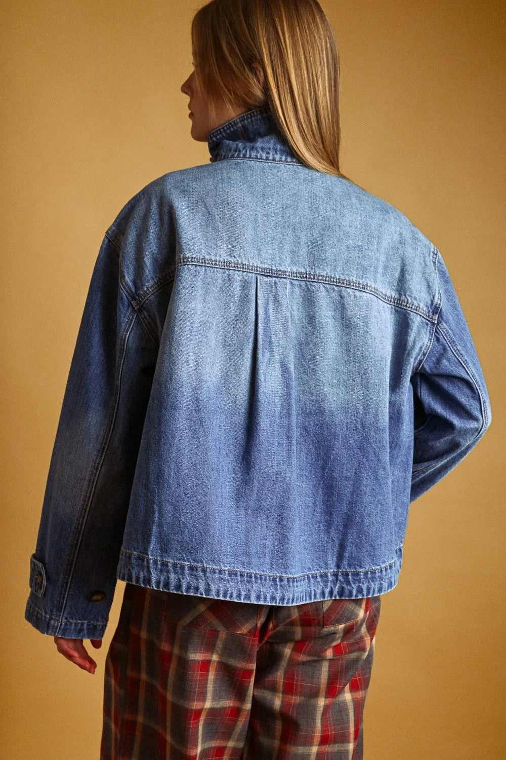 A medium-wash blue denim jacket with relaxed fit and classic stitching in a shirts styled denim jacket design