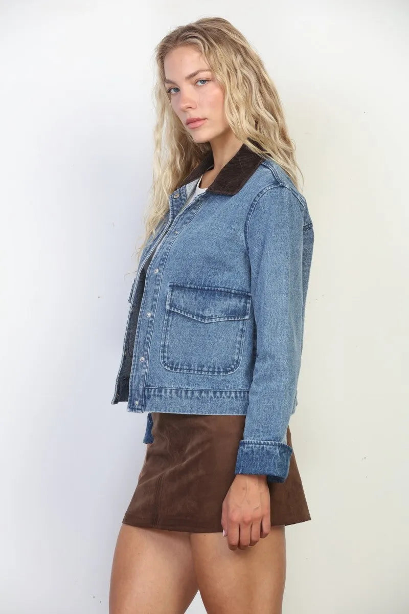 A medium-wash snap closure crop denim jacket with dark brown collar and cuffs featuring two front pockets