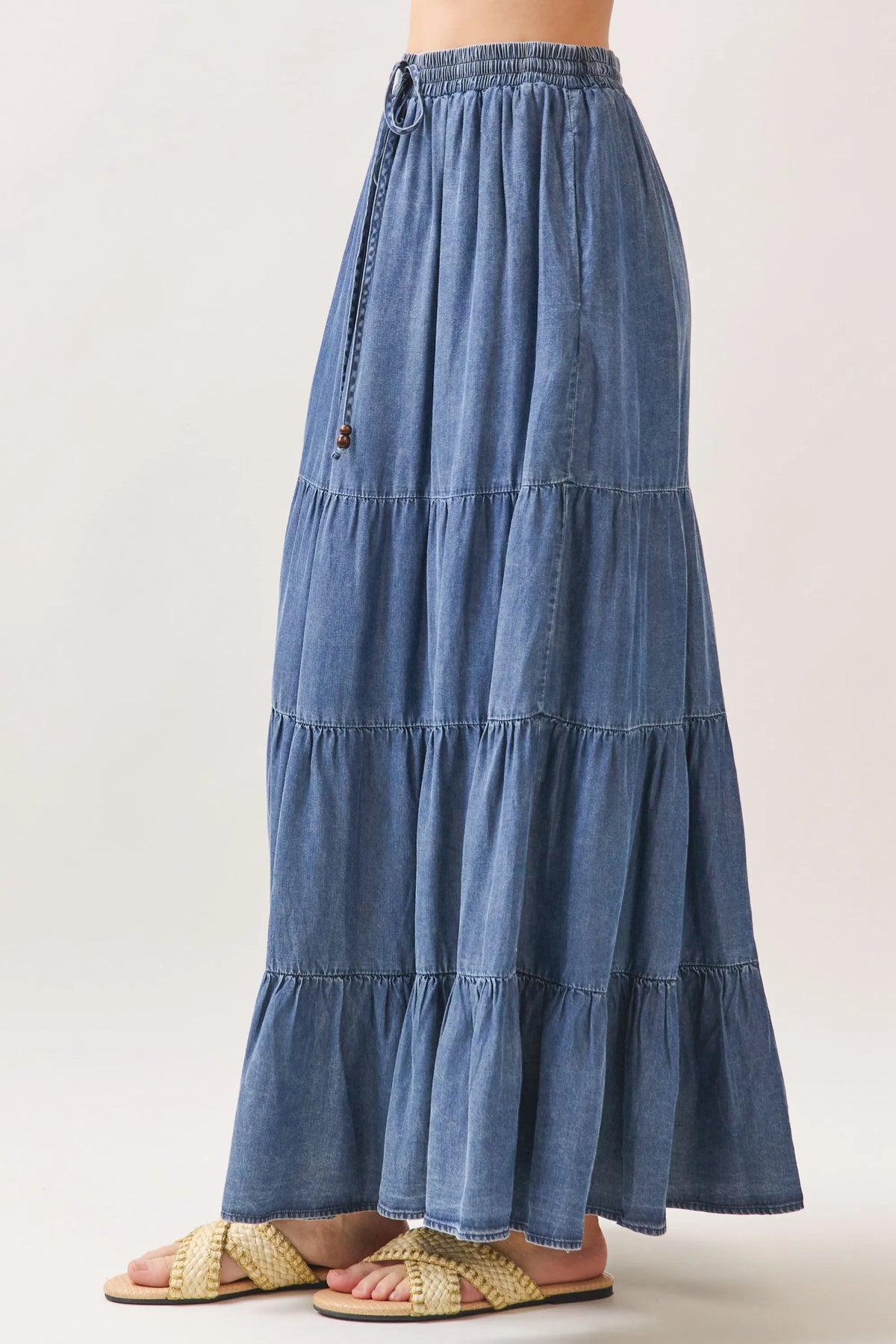 A flowing medium-wash tencel elastic waisted tiered maxi skirt with ruffles and a comfortable fit