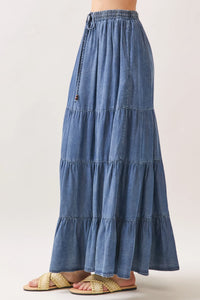 A flowing medium-wash tencel elastic waisted tiered maxi skirt with ruffles and a comfortable fit