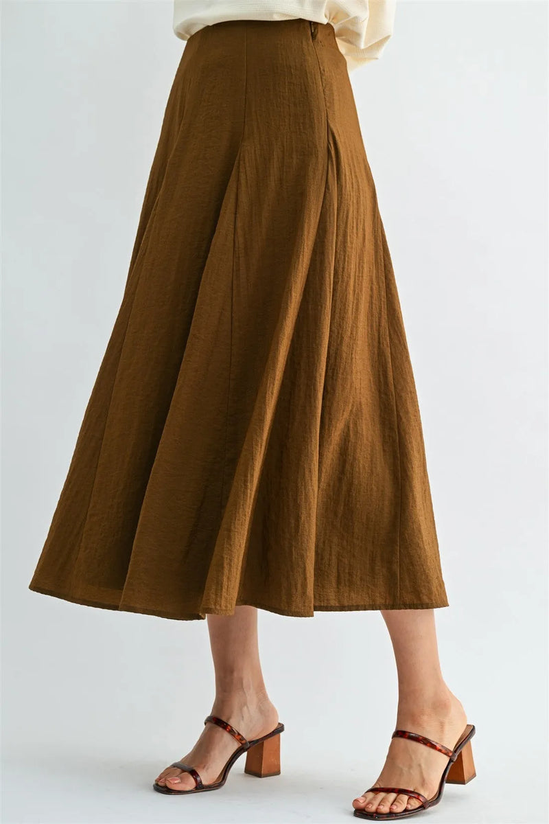 A flowing brown godet midi skirt with subtle textured fabric gentle pleats and side zipper closure