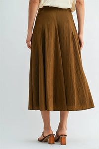 A flowing brown godet midi skirt with soft textured fabric and side zipper in a mid-calf length design