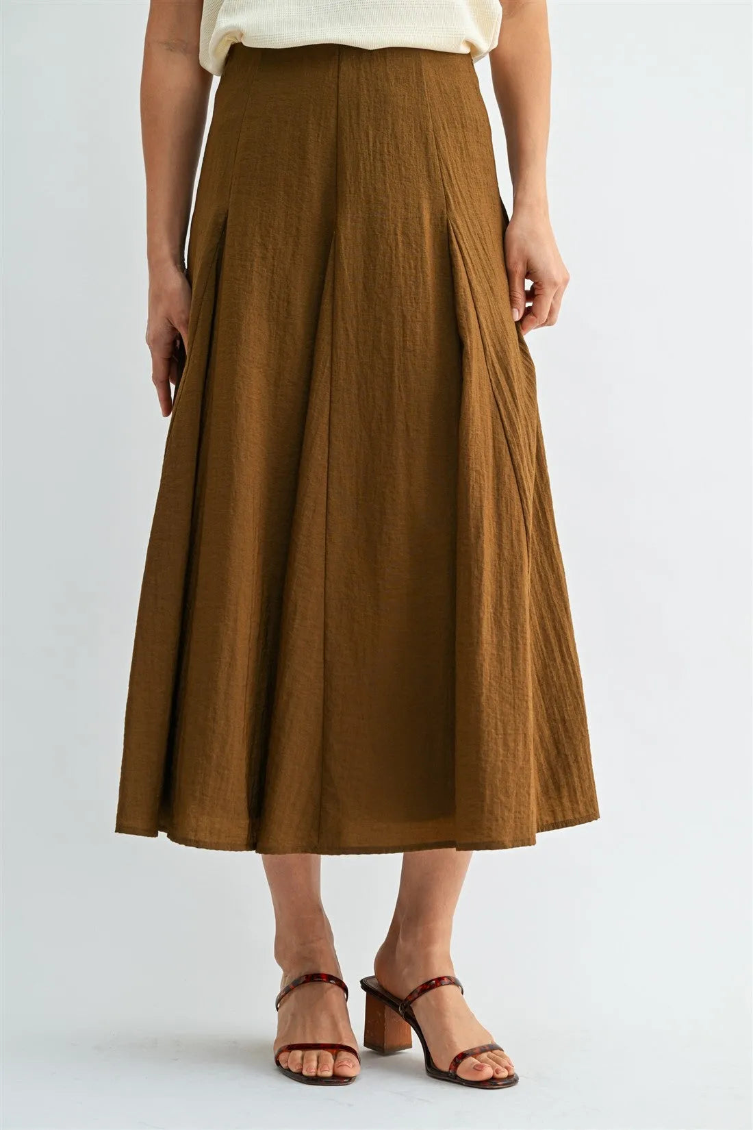 A rich brown godet midi skirt with subtle pleats and lightweight fabric featuring a side zipper closure