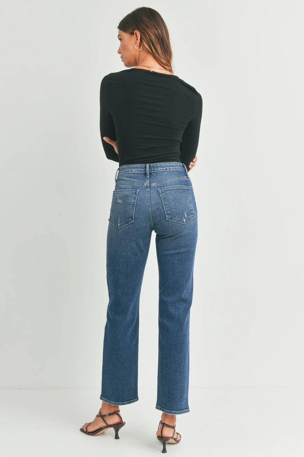 Mid-wash blue high-waisted full length straight denim jean with classic back pockets showing back side view