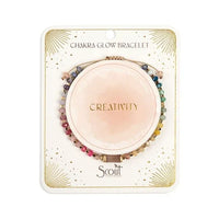 A multicolored beaded chakra glow bracelet with creativity inscription featuring pink blue green and gold stones on string