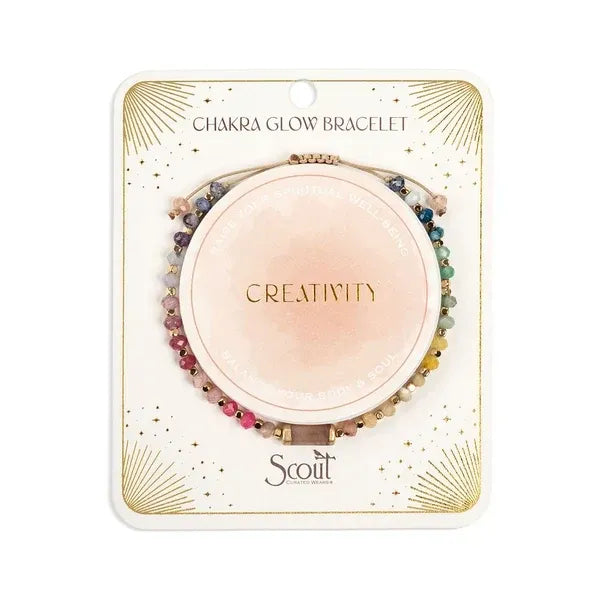 A multicolored beaded chakra glow bracelet with creativity inscription featuring pink blue green and gold stones on string
