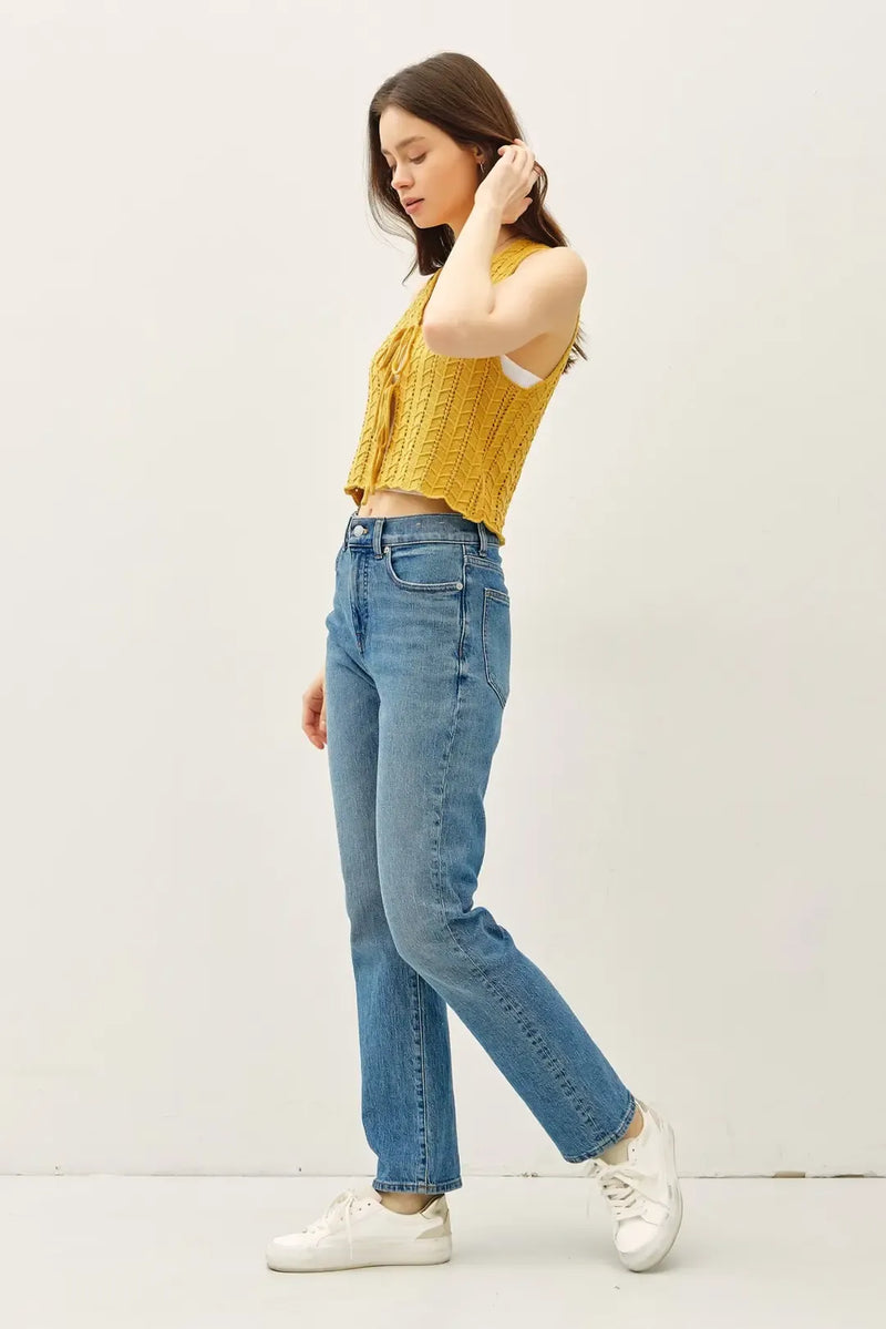 A mustard-yellow ribbed knit crop top featuring a unique wavy knit tie fastening vest design